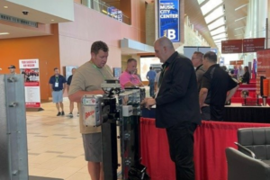 Razor team member discussing trailer automation with a visitor at the NATDA 2026 booth.